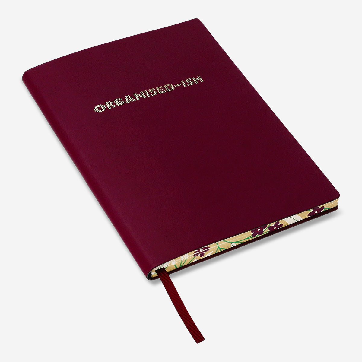 Burgundy Flying Tiger Copenhagen office notebook with printed text on the cover, open showing lined pages inside.