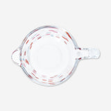 Kitchen measuring cup with cherry print by Flying Tiger Copenhagen, featuring clear markings and a colorful cherry design.