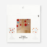 Two Flying Tiger Copenhagen wine glasses with strawberry print, perfect for party gatherings, on a reflective surface.