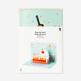 Flying Tiger Copenhagen birthday card with a pop-up slice of cake design, featuring colorful, festive office-themed artwork.