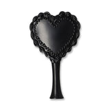 Red and black heart-shaped hairbrush from Flying Tiger Copenhagen for personal care and styling.