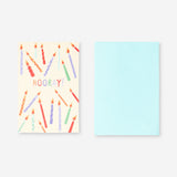 Office greetings card featuring candles and "Hooray" message by Flying Tiger Copenhagen, with colorful design and festive elements.