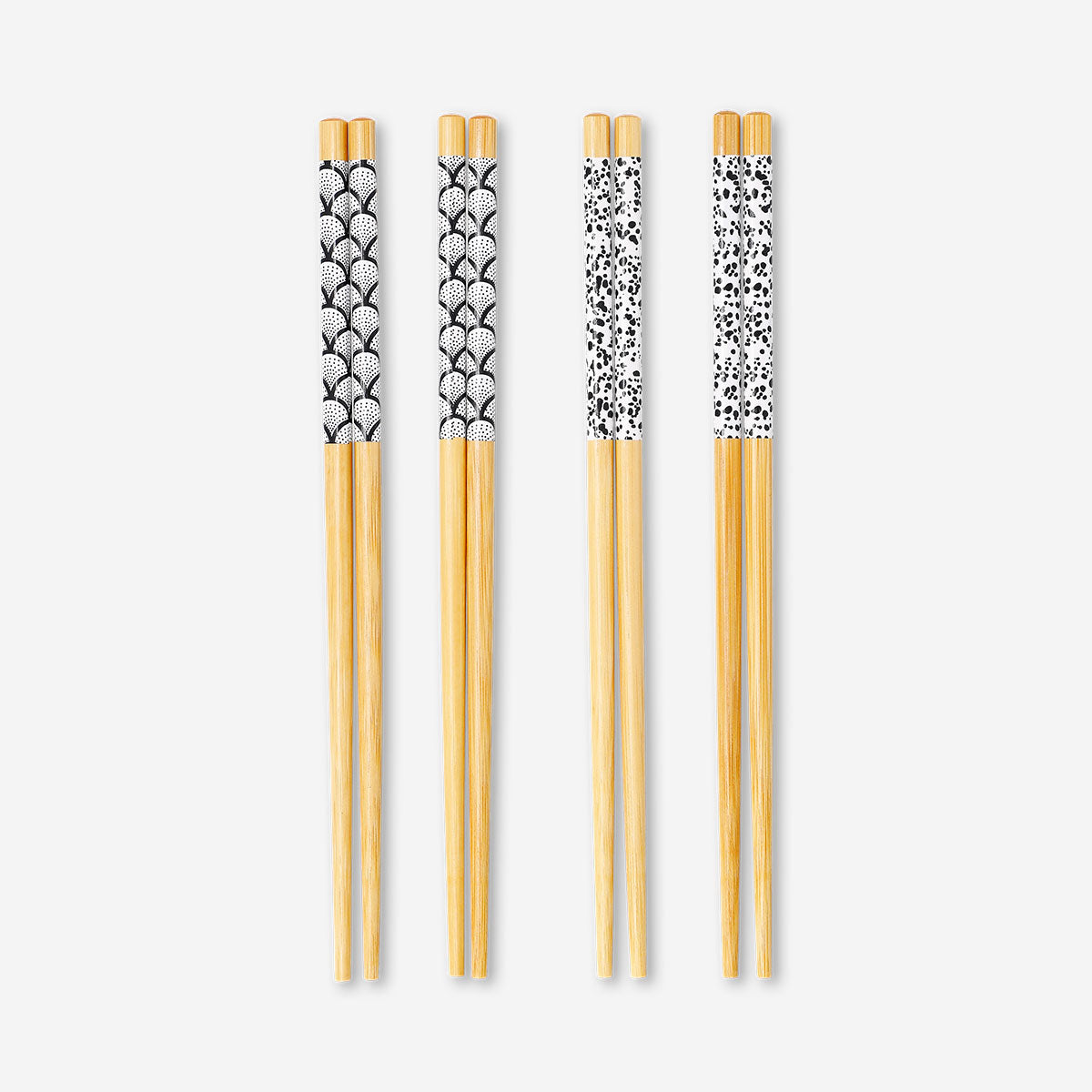 Set of 8 Flying Tiger Copenhagen kitchen chopsticks with colorful printed designs on smooth wood.