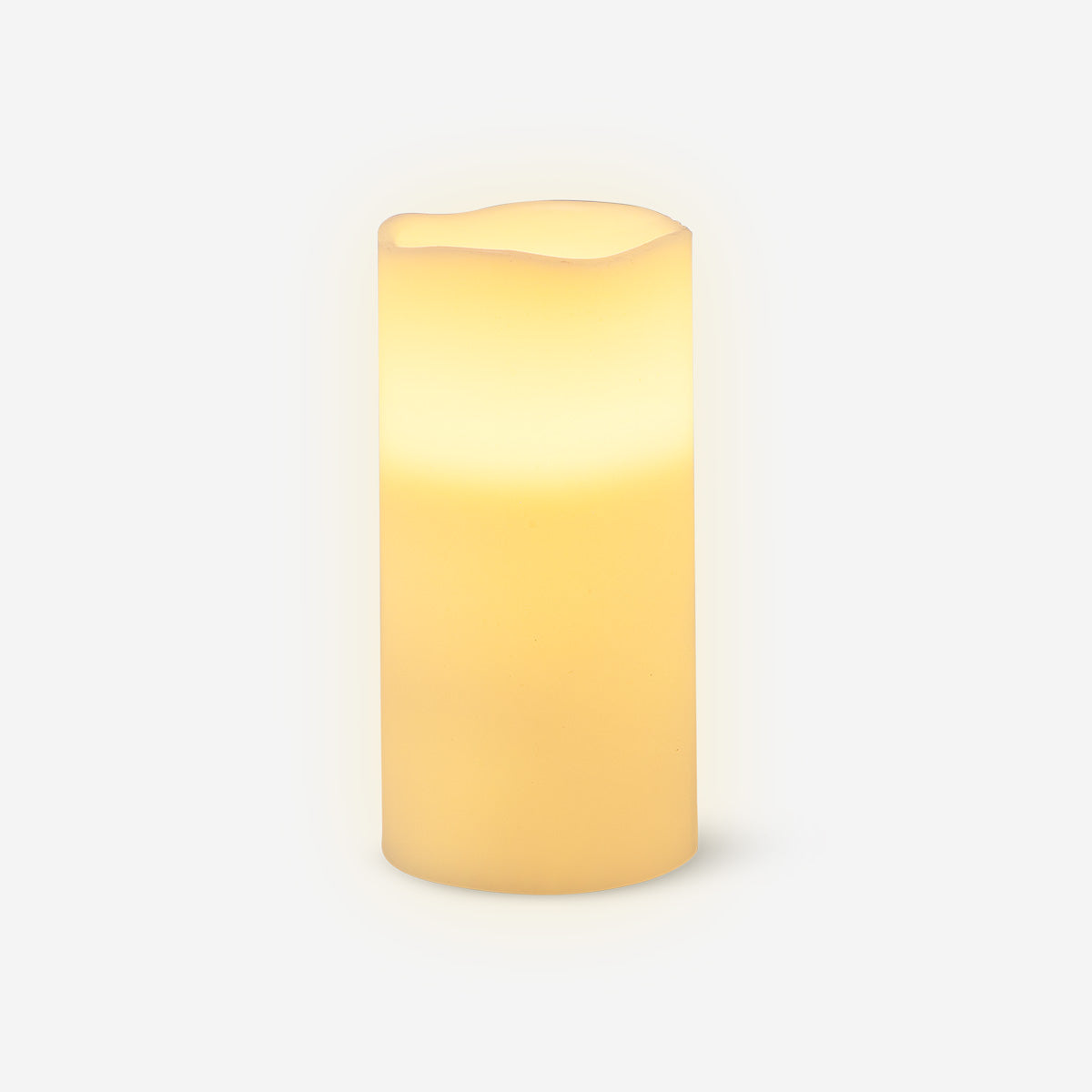 White LED pillar candle, 15 cm tall, from Flying Tiger Copenhagen, glowing softly on a home decor surface.
