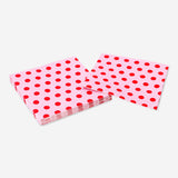 Pink paper napkins with red dots, 16-piece party set from Flying Tiger Copenhagen, shown folded on a table.