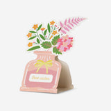 Office greetings card with floral vase design by Flying Tiger Copenhagen, featuring colorful flowers and a cheerful "Best wishes" message.