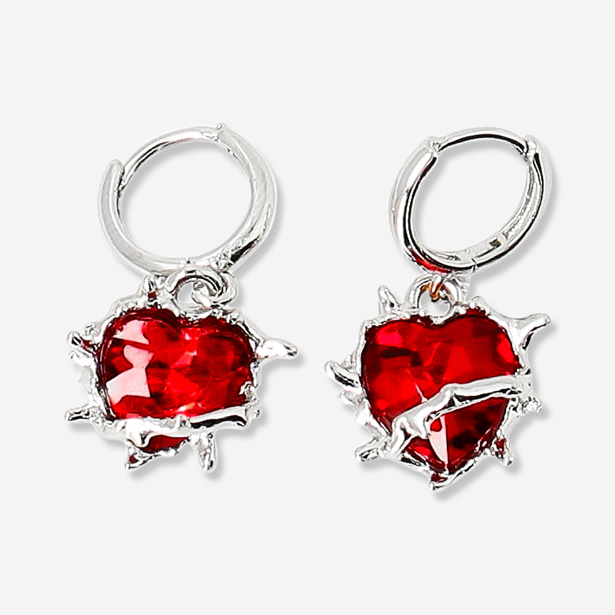 Red heart-shaped textile hanging earrings with spikes, stylish and playful jewelry by Flying Tiger Copenhagen.