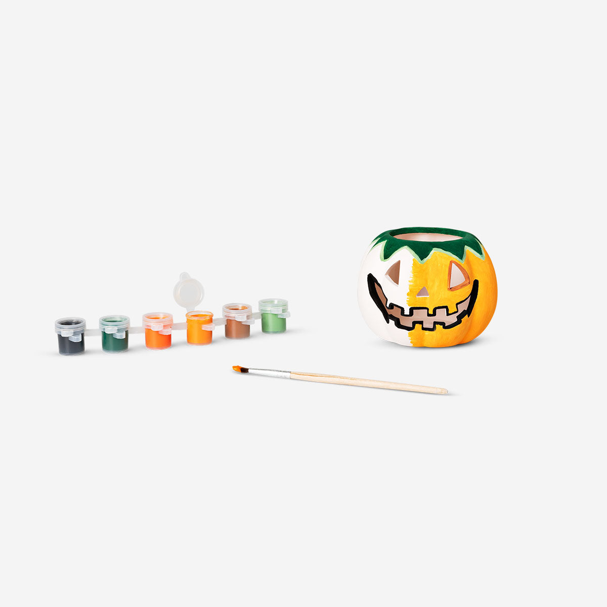 DIY pumpkin tealight holder craft kit by Flying Tiger Copenhagen with paint, brush, and materials for decorating a pumpkin.