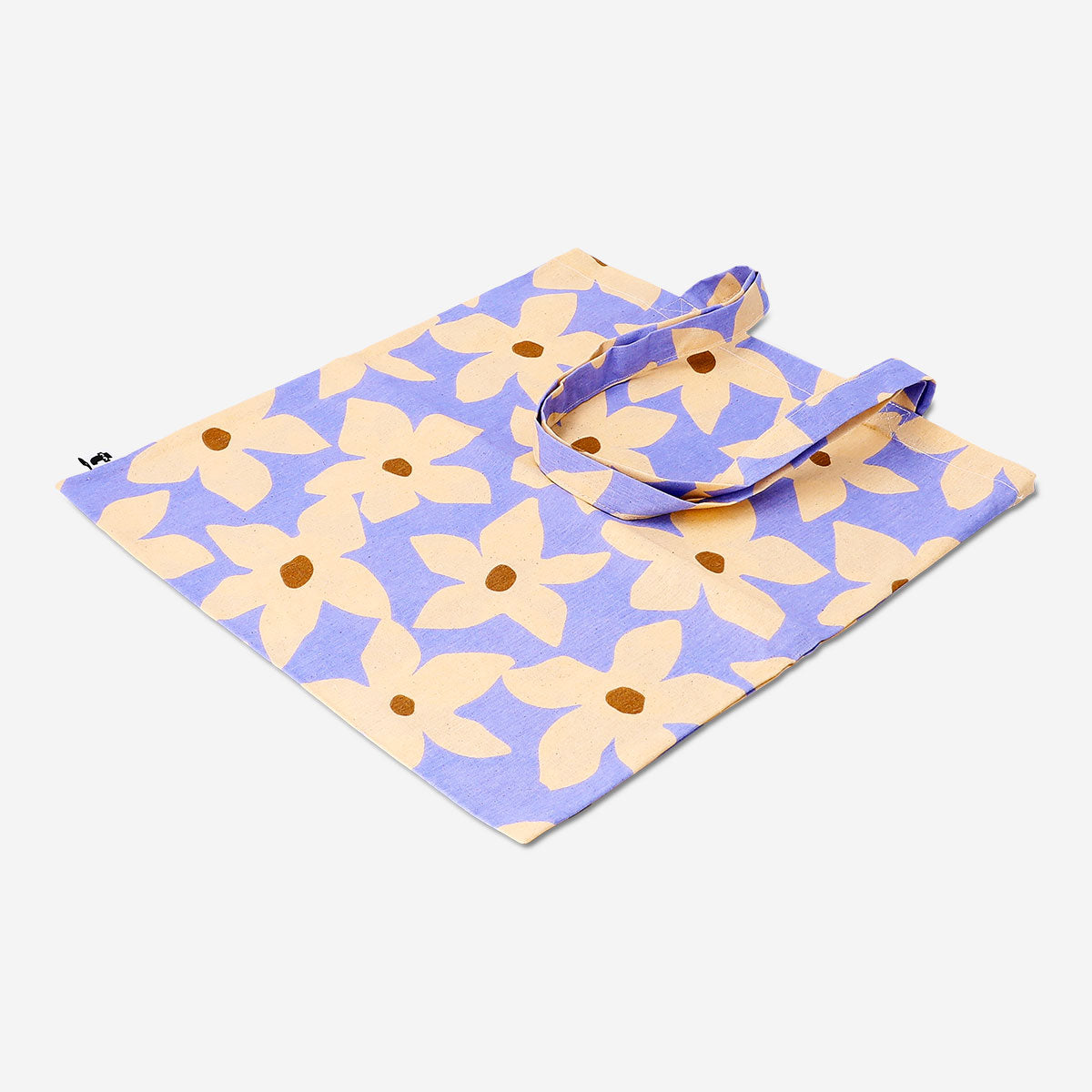 Textile tote bag with colorful flower print from Flying Tiger Copenhagen, shown with handles and floral design on fabric.