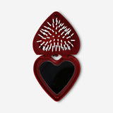 Foldable heart-shaped hairbrush with mirror by Flying Tiger Copenhagen, personal care accessory, compact and portable for styling on the go.