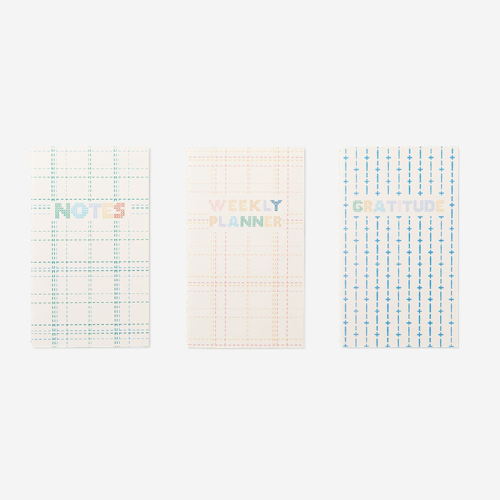 Set of three Flying Tiger Copenhagen office planners with colorful covers and organized pages for daily scheduling and note-taking.