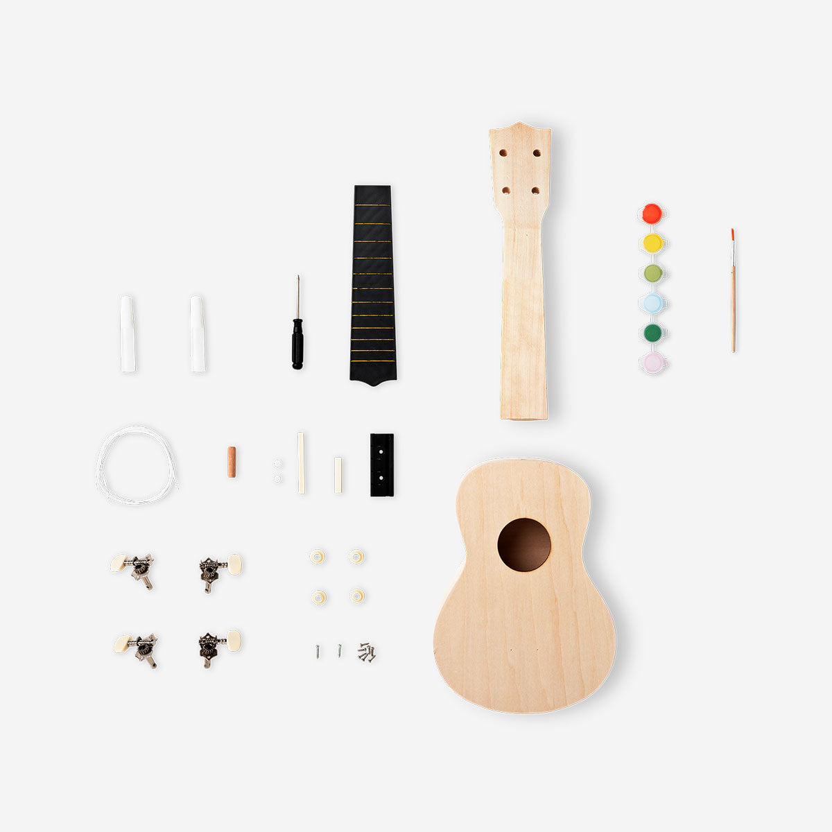 DIY ukulele kit with paint from Flying Tiger Copenhagen, featuring a small wooden ukulele and colorful painting supplies for hobby crafting.