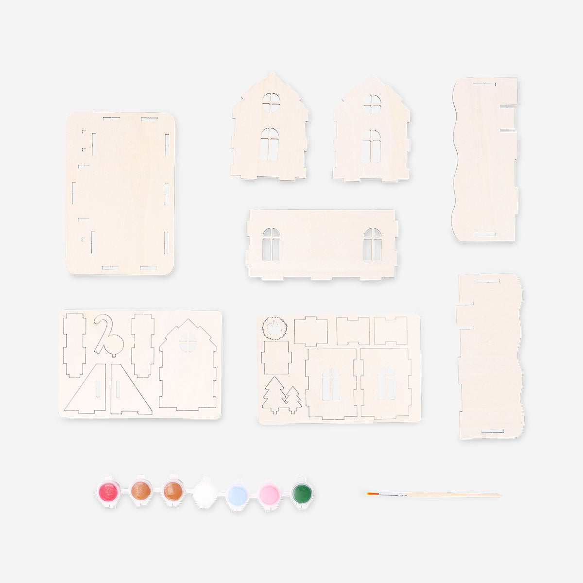 DIY wooden gingerbread house hobby kit by Flying Tiger Copenhagen, showing assembled miniature gingerbread house with detailed wooden parts.