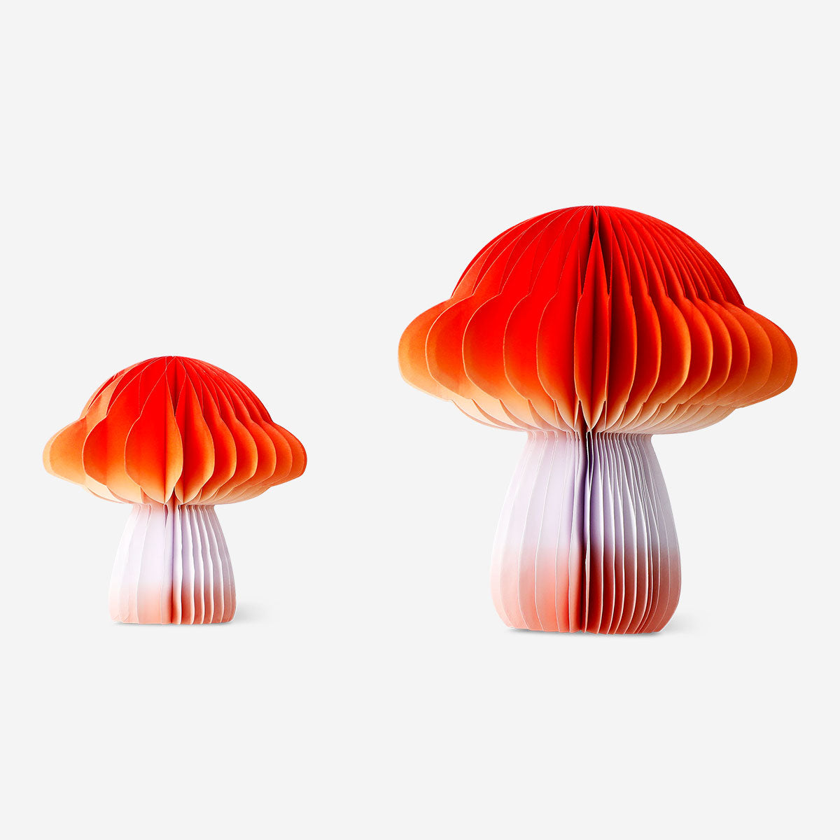 Two honeycomb paper gradient mushroom decorations for party from Flying Tiger Copenhagen, featuring colorful, textured paper mushrooms.
