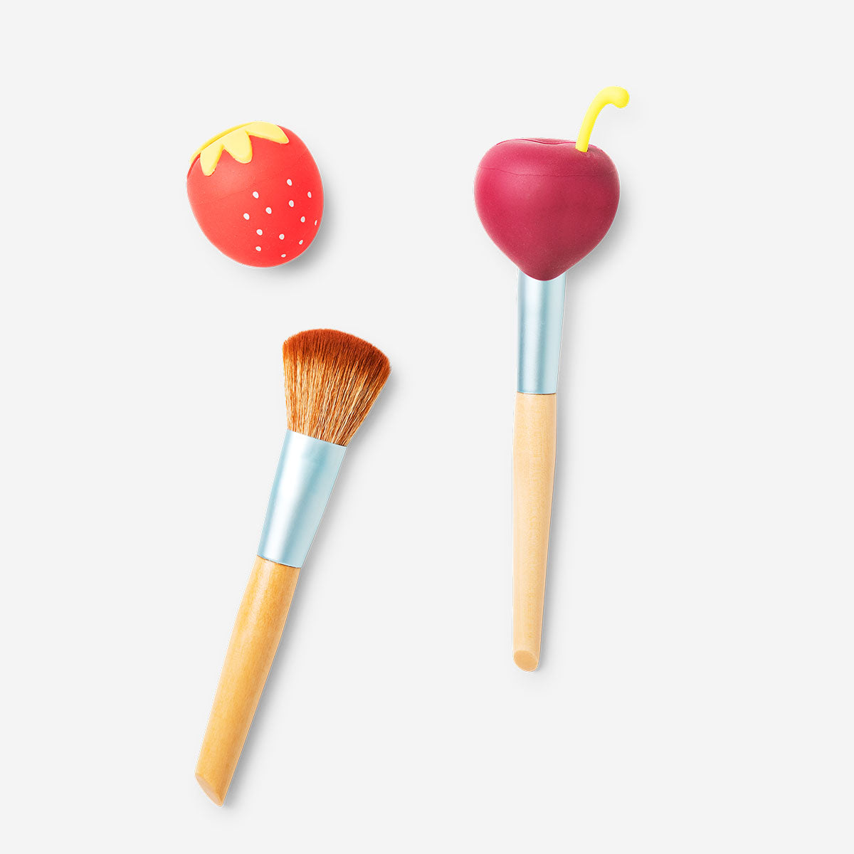 Two berry-shaped makeup brush covers in vibrant red and green, designed to protect and organize beauty brushes.