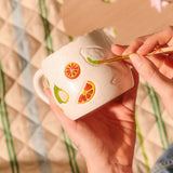 DIY ceramic mug with debossed fruit design, 330 ml capacity, by Flying Tiger Copenhagen, featuring colorful fruit patterns.