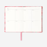 Red floral weekly planner from Flying Tiger Copenhagen with colorful flower patterns on a smooth cover.