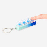Flying Tiger Copenhagen clicking keyring gadget with built-in light, featuring a compact design and a fun clicking mechanism.