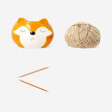 Colorful knitting set with ceramic yarn bowl for hobby knitting, featuring needles, yarn, and accessories in a vibrant display.