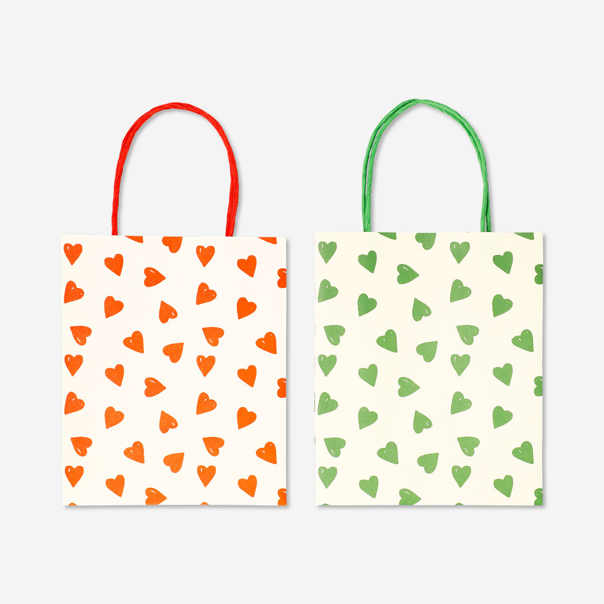 Two office gift bags with heart designs from Flying Tiger Copenhagen, featuring bright colors and decorative handles.