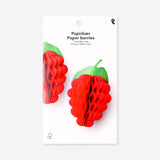 Two honeycomb paper berry decorations for parties, featuring vibrant red berries and green leaves, by Flying Tiger Copenhagen.