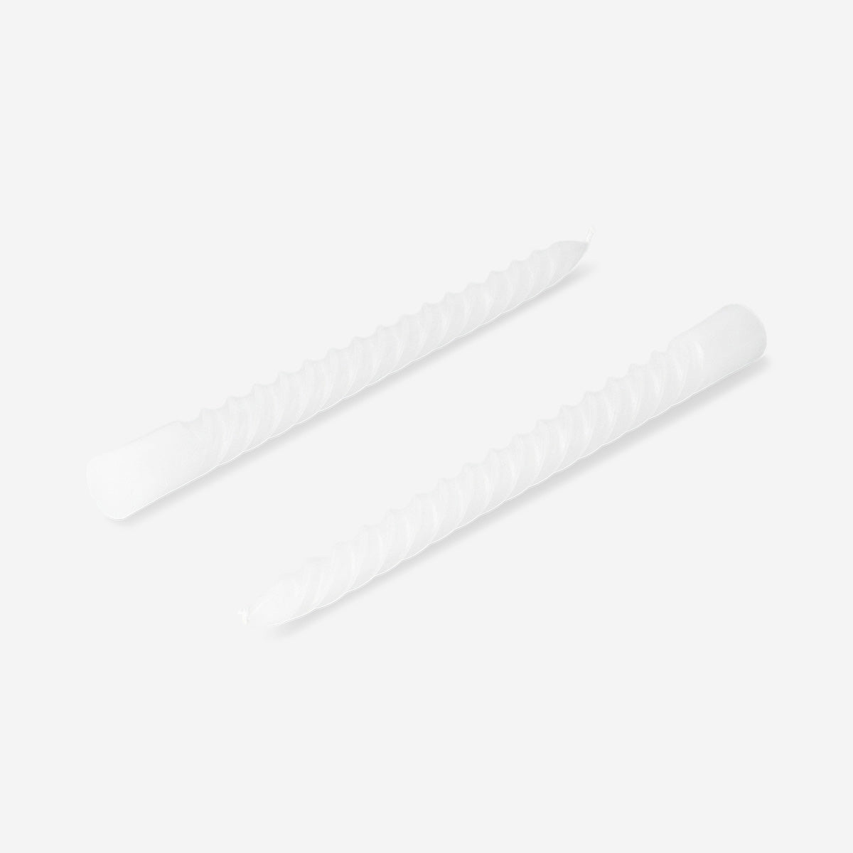 Set of four white twisted dinner candles for home décor by Flying Tiger Copenhagen, displayed on a candle holder.