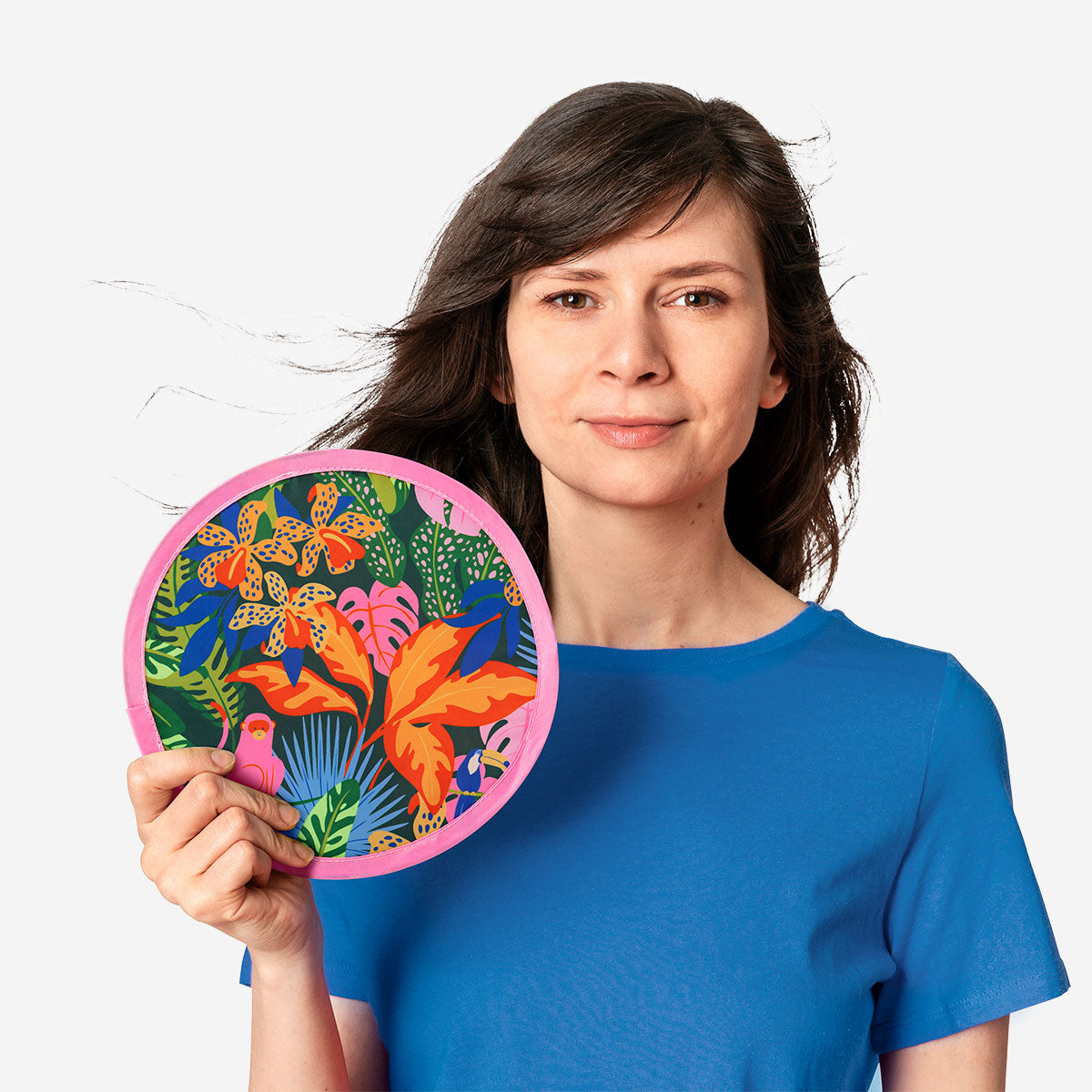 Foldable textile fan with tropical print by Flying Tiger Copenhagen, showing the colorful, lightweight, portable fan open and ready to use.