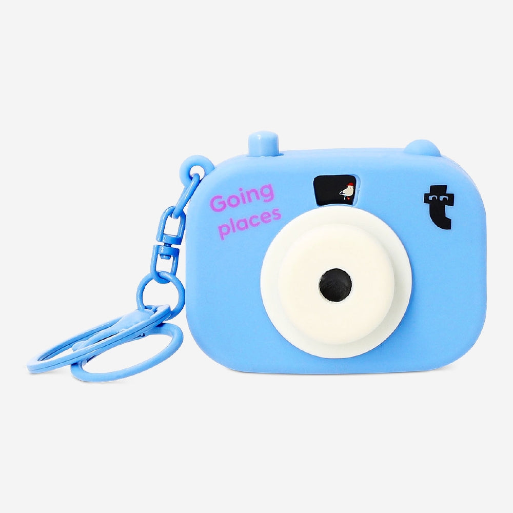 Mini projector camera gadget from Flying Tiger Copenhagen showing compact device with lens and control buttons.