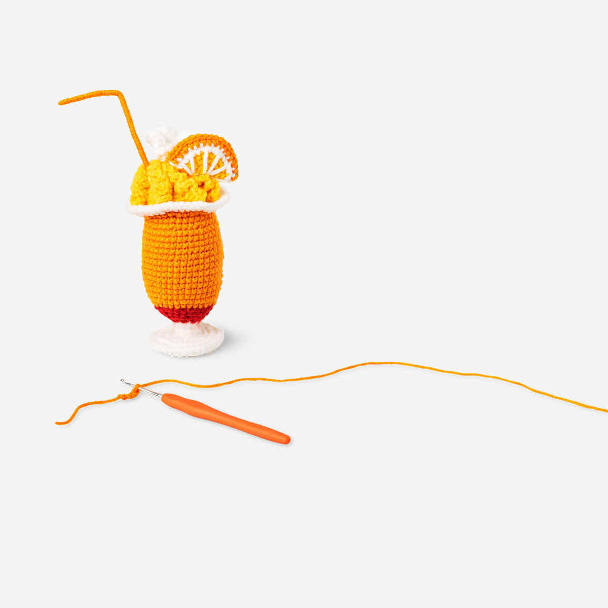 Crochet tropical drink hobby kit by Flying Tiger Copenhagen showing colorful crochet drink with straw and decorative elements.