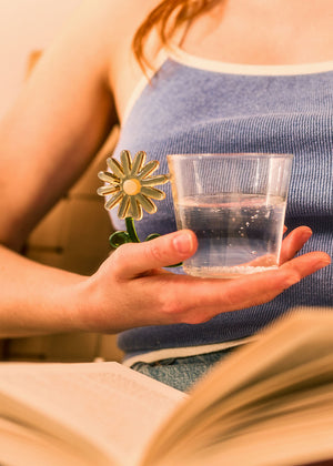 Clear glass drinking glass with a yellow flower handle, 230 ml capacity, from Flying Tiger Copenhagen kitchen collection.