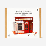 DIY wooden bookstore hobby kit by Flying Tiger Copenhagen, showing assembled mini bookcase with small wooden books and shelves.