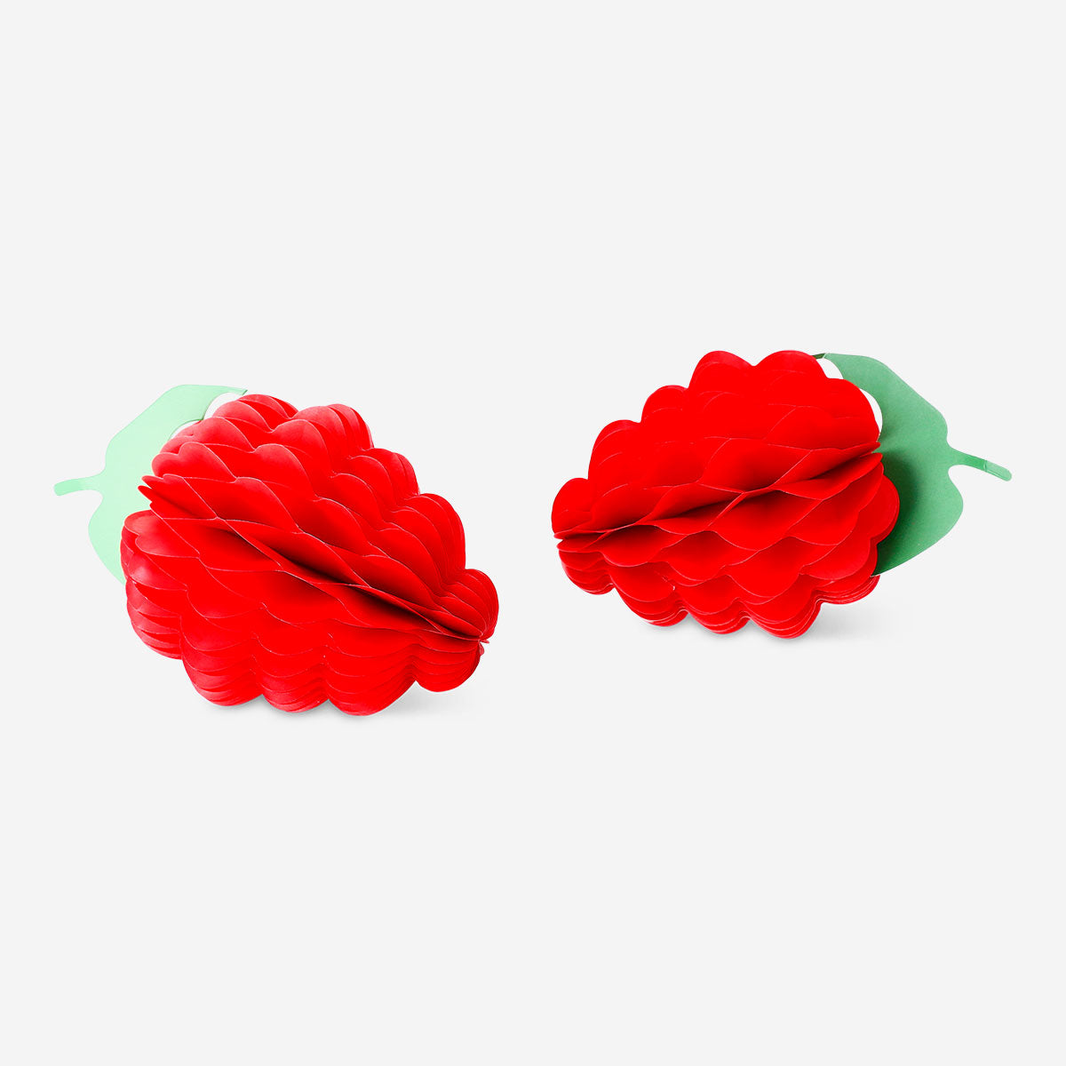 Two honeycomb paper berry decorations in pink and white for party decor, from Flying Tiger Copenhagen.