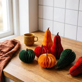 Six colorful honeycomb paper pumpkin decorations for party decor, featuring vibrant orange and yellow tones.