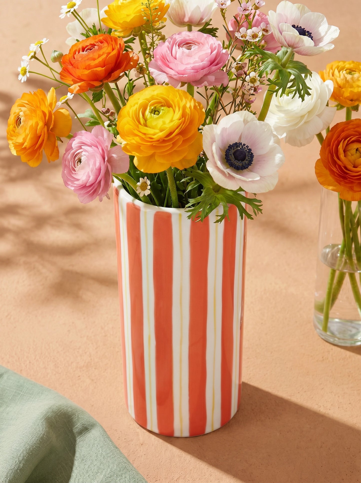 Orange striped ceramic vase from Flying Tiger Copenhagen, 20 cm tall, with flowers inside, designed for home decor.