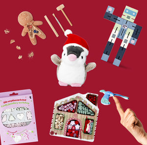 Assorted Christmas gift ideas displayed on a red background, including a plush penguin in a Santa hat, candy jewellery workshop kit, gingerbread dig toy, wooden robot figure, craft bead house set, and a finger-spinning bird toy.