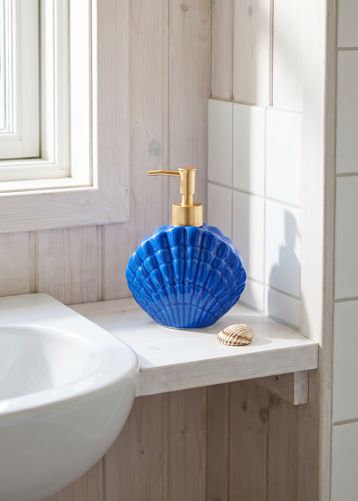 Blue ceramic seashell soap dispenser for home use, featuring a detailed seashell design and a pump top from Flying Tiger Copenhagen.