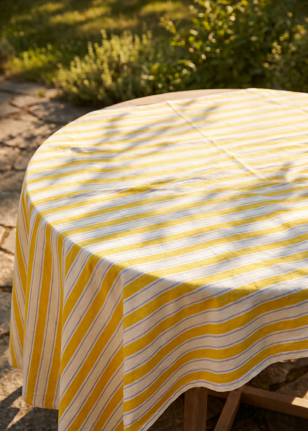 Yellow striped tablecloth from Flying Tiger Copenhagen, 140x220 cm, with bold yellow and white stripes on a smooth fabric surface.