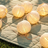 Outdoor string lights with striped fabric ball covers, ideal for home patio or garden decor by Flying Tiger Copenhagen