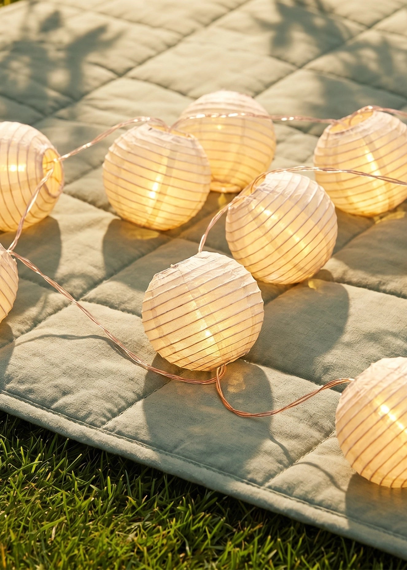 Outdoor string lights with striped fabric ball covers, ideal for home patio or garden decor by Flying Tiger Copenhagen