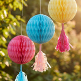 Three colorful paper pom poms for hanging, perfect for party decor, featuring vibrant summer garden colors from Flying Tiger Copenhagen.