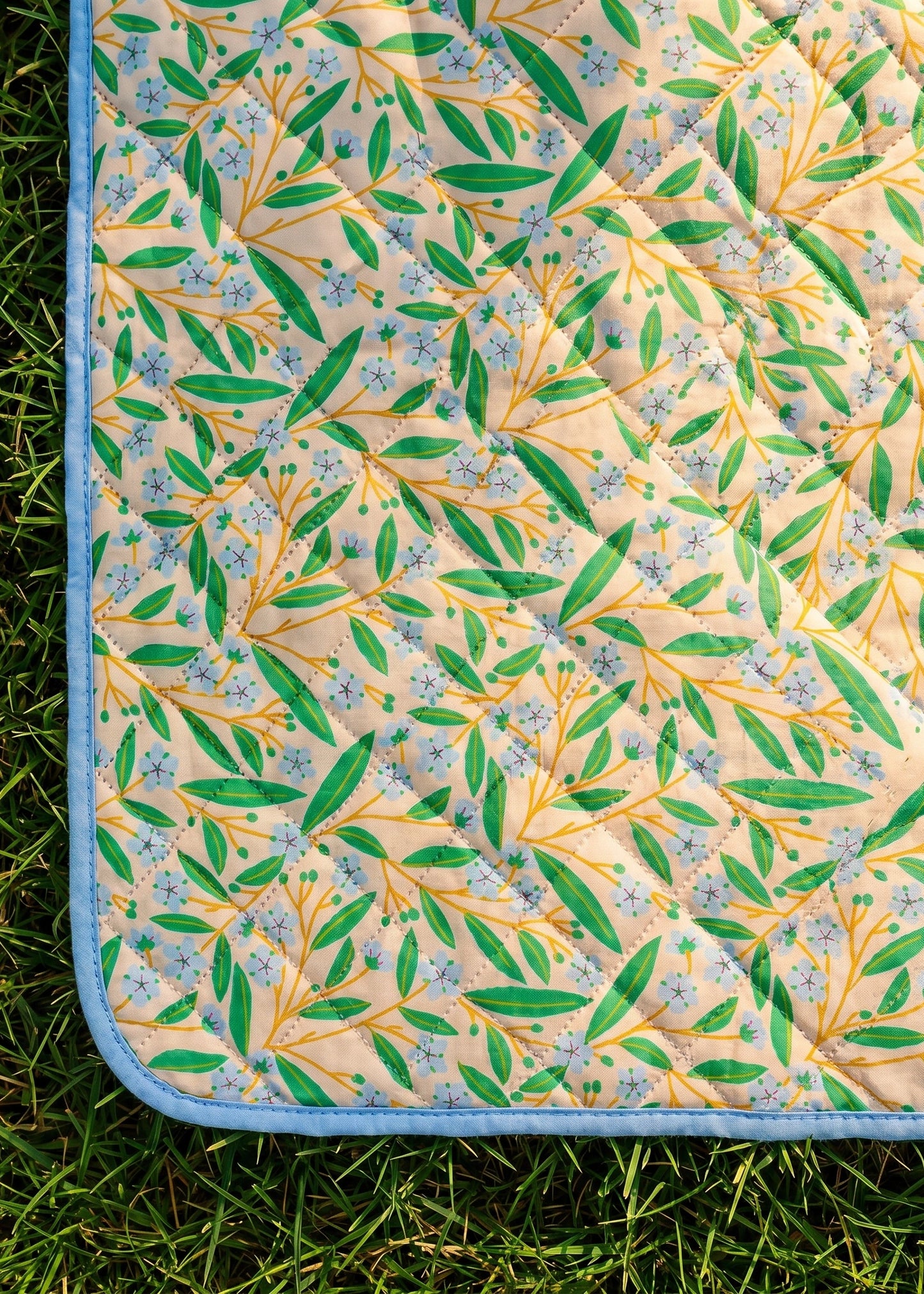 Flying Tiger Copenhagen quilted blanket in summer garden style, measuring 170x130 cm, with floral and leafy patterns.