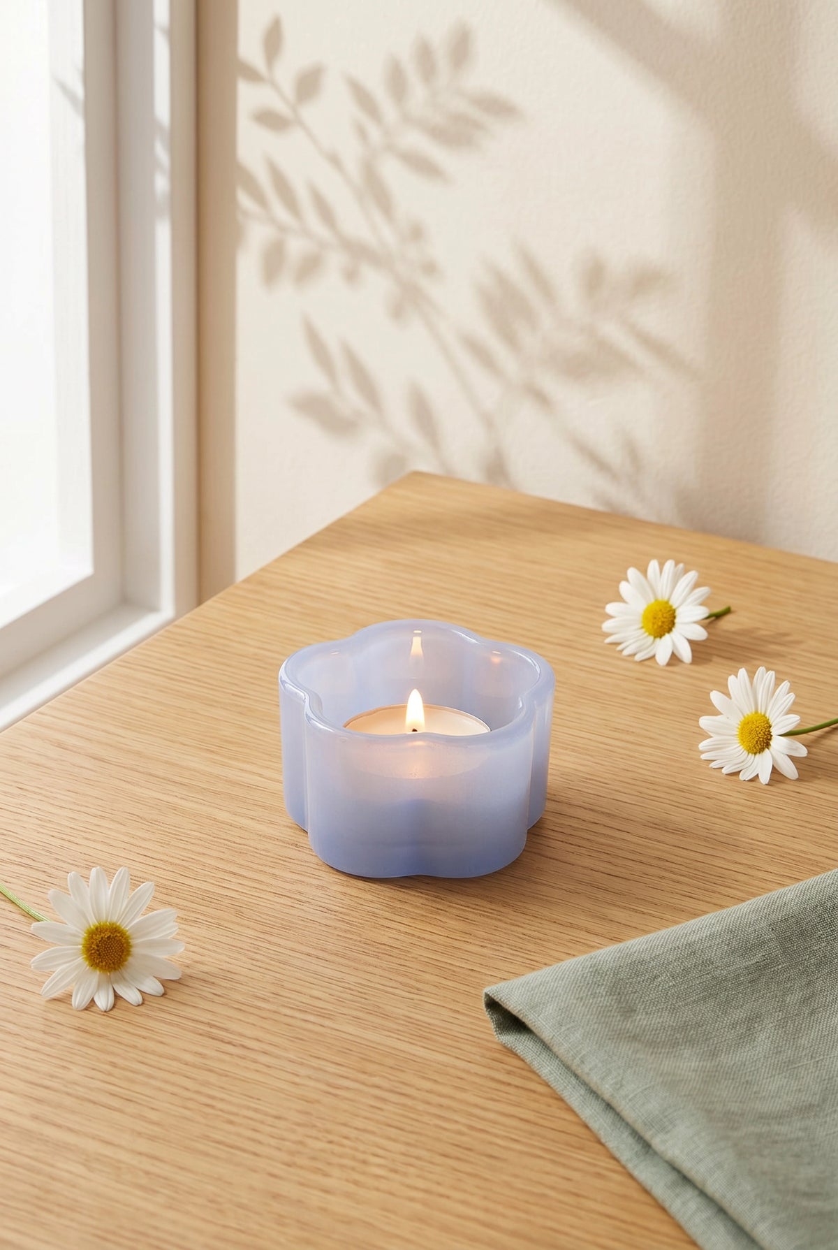 Milky blue glass tealight holder for home decor, designed by Flying Tiger Copenhagen, with a smooth, rounded shape and transparent finish.