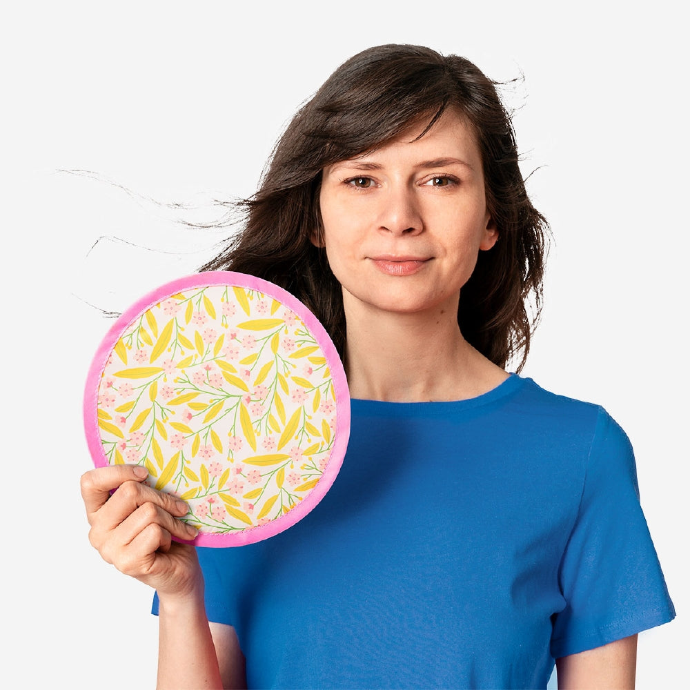 Foldable textile fan with colorful flower print from Flying Tiger Copenhagen, open showcasing its vibrant design and lightweight structure.
