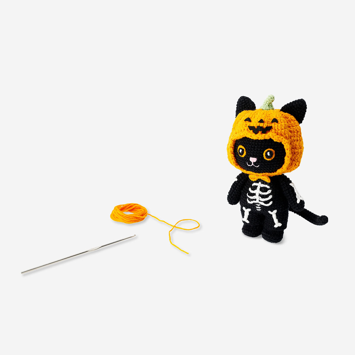 DIY crochet Halloween cat hobby kit by Flying Tiger Copenhagen, featuring colorful yarn, crochet hooks, and accessories for crafting a festive feline.