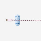 Two blue adhesive cable organizers from Flying Tiger Copenhagen for keeping media cables tidy and secure.