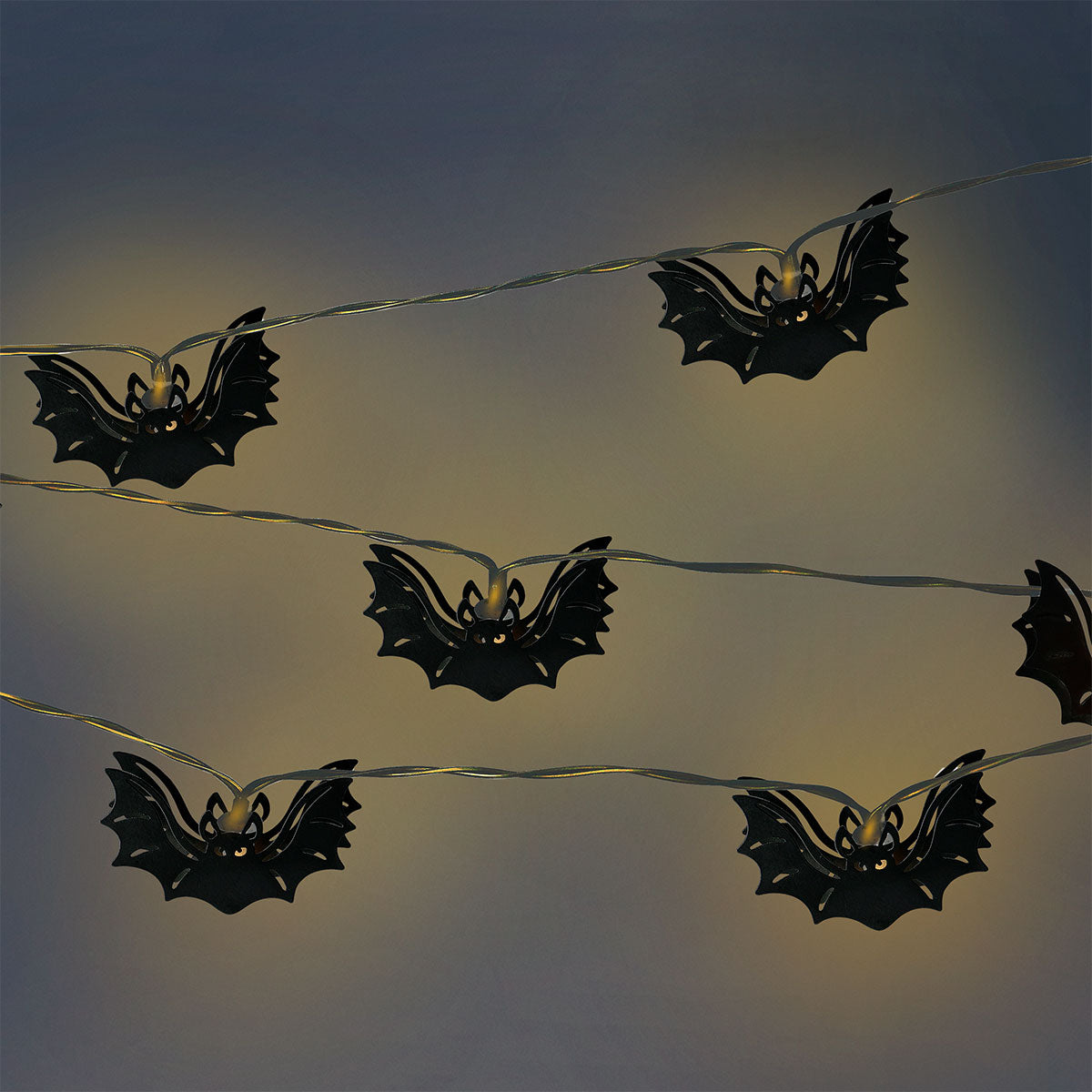 Black bat-shaped string lights for home decor, featuring Flying Tiger Copenhagen's playful design with illuminated bat figures.
