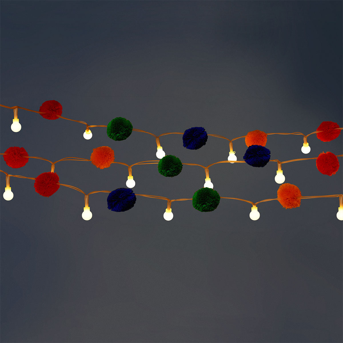 Colorful string lights with multi-colored pompoms for home decor, designed by Flying Tiger Copenhagen.