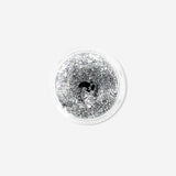 Silver glitter eyeshadow flakes from Flying Tiger Copenhagen, close-up of shimmering cosmetic flakes for eye makeup.