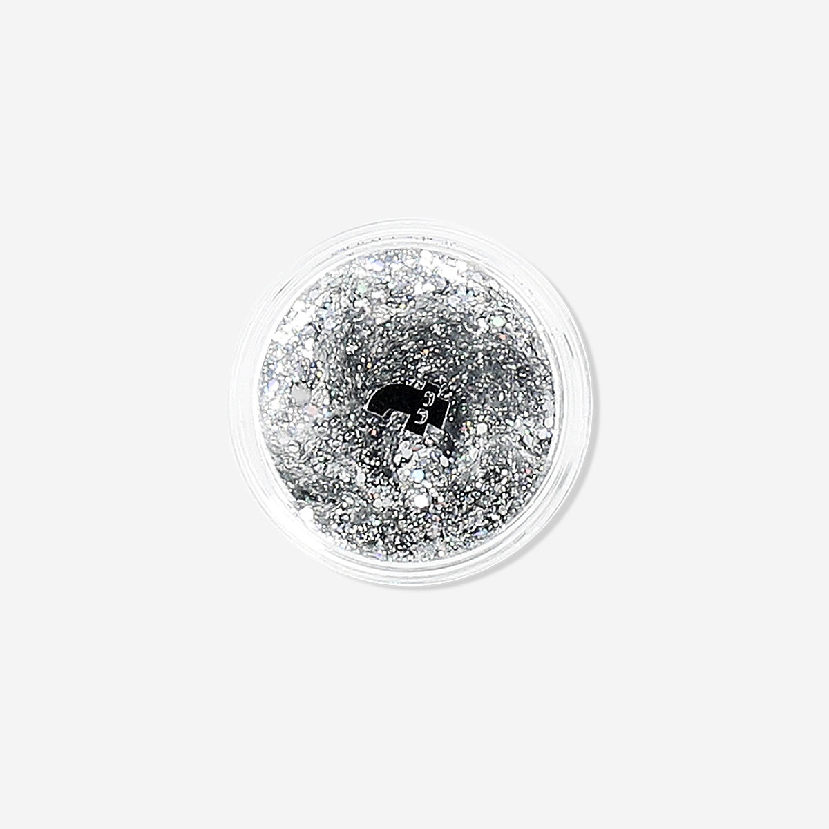Silver glitter eyeshadow flakes from Flying Tiger Copenhagen, close-up of shimmering cosmetic flakes for eye makeup.