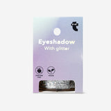 Silver glitter eyeshadow flakes from Flying Tiger Copenhagen, close-up of shimmering, reflective cosmetic flakes for eye makeup.